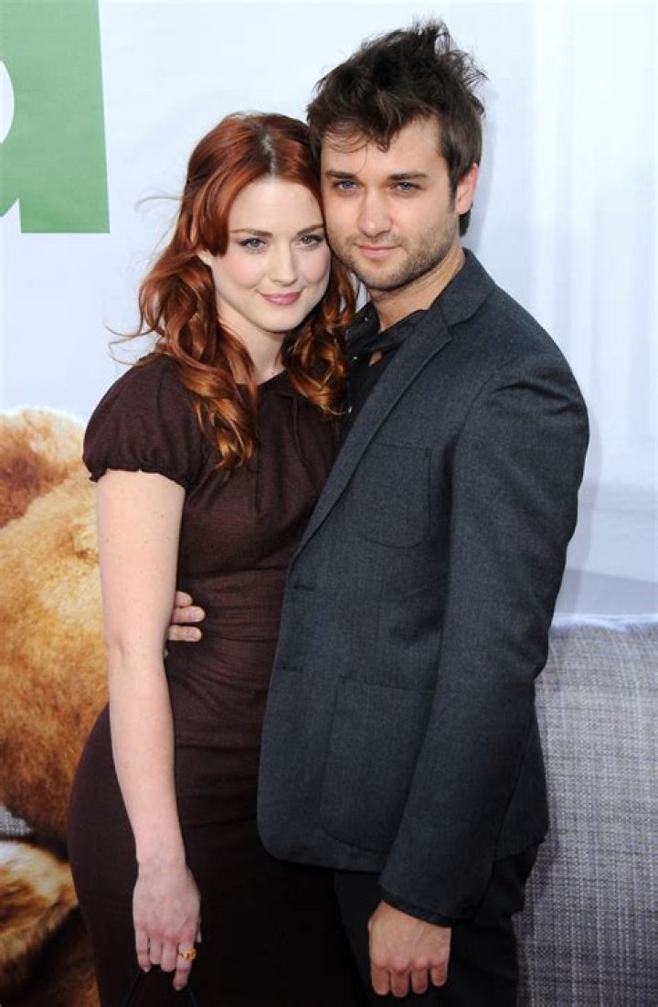 Alexandra Breckenridge and husband Casey Hooper each holding a baby in their hands at the front porch of their Atlanta home.